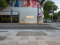 the sidewalk has lights on for people to walk through at night in the city area