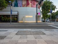 the sidewalk has lights on for people to walk through at night in the city area