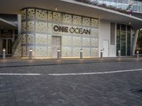 the facade of a building with the words one ocean on it at night time and a street corner