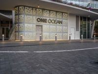 the facade of a building with the words one ocean on it at night time and a street corner