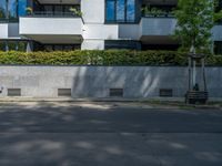 there is a red fire hydrant on the sidewalk of this building with trees outside