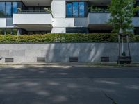 there is a red fire hydrant on the sidewalk of this building with trees outside