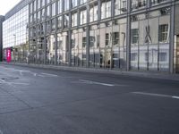 a large building is reflected in the side of the street that goes along this narrow road