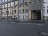 a large building is reflected in the side of the street that goes along this narrow road