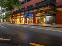 the empty street is surrounded by tall buildings and shops on both sides of the street