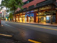 the empty street is surrounded by tall buildings and shops on both sides of the street