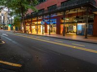 the empty street is surrounded by tall buildings and shops on both sides of the street