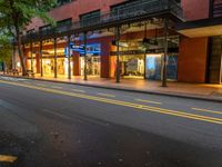 the empty street is surrounded by tall buildings and shops on both sides of the street