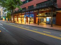 the empty street is surrounded by tall buildings and shops on both sides of the street