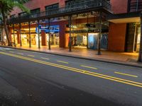 the empty street is surrounded by tall buildings and shops on both sides of the street