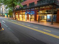 the empty street is surrounded by tall buildings and shops on both sides of the street