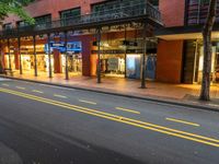 the empty street is surrounded by tall buildings and shops on both sides of the street