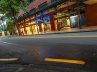 the empty street is surrounded by tall buildings and shops on both sides of the street