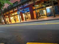 the empty street is surrounded by tall buildings and shops on both sides of the street