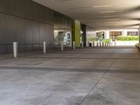 a metal barrier sits near the outside entrance to the building as people walk by the windows