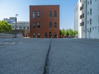 a street with a building near the building in the middle and on the left of which is a parking lot, as shown in this photo