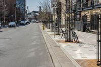 some bikes are parked on a street next to buildings and trees, a fire hydrant and a car