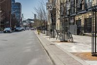 some bikes are parked on a street next to buildings and trees, a fire hydrant and a car