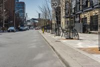 some bikes are parked on a street next to buildings and trees, a fire hydrant and a car