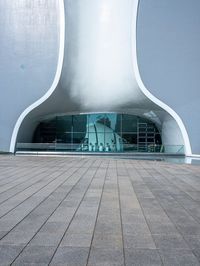 a very modern building made from concrete and glass with a small window and railings