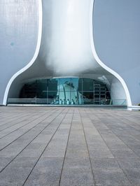 a very modern building made from concrete and glass with a small window and railings