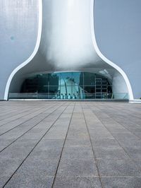 a very modern building made from concrete and glass with a small window and railings