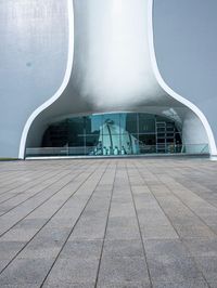 a very modern building made from concrete and glass with a small window and railings