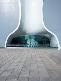 a very modern building made from concrete and glass with a small window and railings