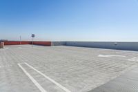 an empty parking lot with a view over the top of the city skyline from a rooftop