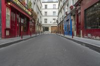 two buildings are in the background and an empty street that is near them is very narrow, and only in this view you can see the corner