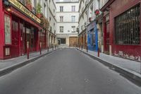 two buildings are in the background and an empty street that is near them is very narrow, and only in this view you can see the corner