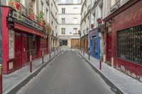 two buildings are in the background and an empty street that is near them is very narrow, and only in this view you can see the corner