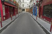 two buildings are in the background and an empty street that is near them is very narrow, and only in this view you can see the corner