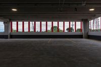 a large parking garage is shown with red and white stripes on the windows on the wall