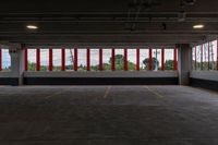 a large parking garage is shown with red and white stripes on the windows on the wall