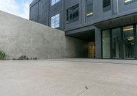 the back end of an office building with large windows and no fire hydrant,