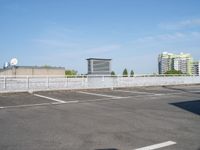 an empty parking lot with no people outside in the daytime sun in a city setting