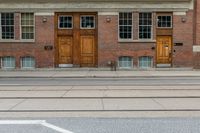 an old school building with wooden windows and a sign on the street that says parking