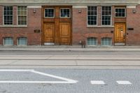 an old school building with wooden windows and a sign on the street that says parking