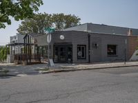 a store on the corner in a small town that has lots of gray brick walls