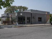 a store on the corner in a small town that has lots of gray brick walls