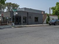 a store on the corner in a small town that has lots of gray brick walls