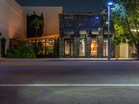 a light pole in front of a restaurant lit up by streetlights at night time