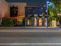 a light pole in front of a restaurant lit up by streetlights at night time