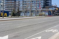 a bicycle lane is left in the middle of a city street in front of a high rise building