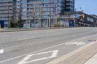 a bicycle lane is left in the middle of a city street in front of a high rise building