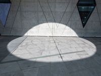 a close up of a building that's on the ground outside of it are multiple triangles of light reflected on the wall