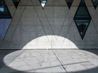 a close up of a building that's on the ground outside of it are multiple triangles of light reflected on the wall
