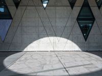 a close up of a building that's on the ground outside of it are multiple triangles of light reflected on the wall