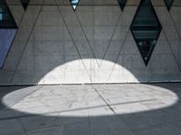 a close up of a building that's on the ground outside of it are multiple triangles of light reflected on the wall